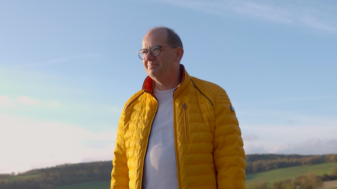 Portrait von Jörg Bieg auf einem Feld bei Sonnenschein.